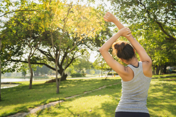 Healthy young Asian runner woman warm up the body stretching bef