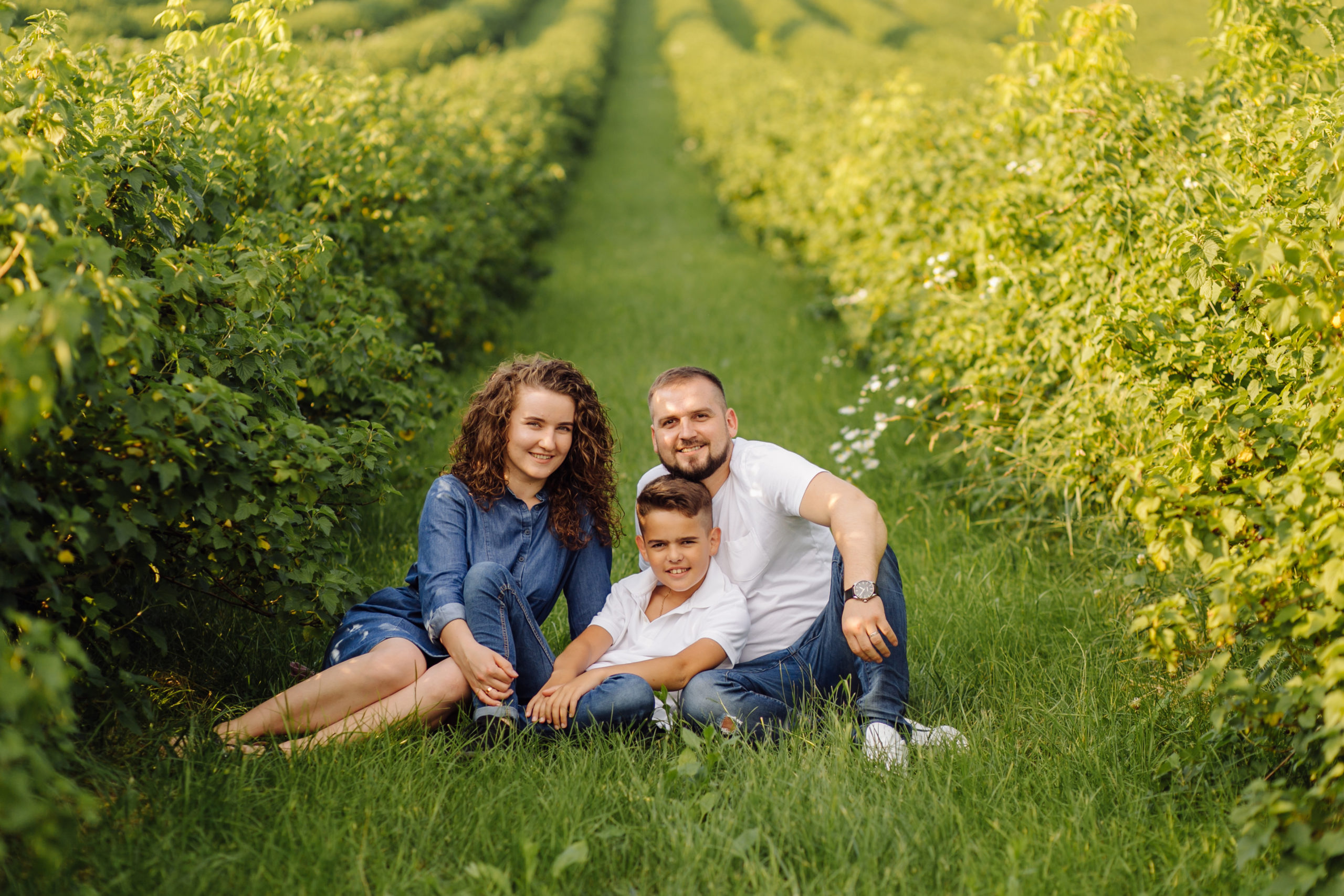 Young family looking at the camera while walking in the garden